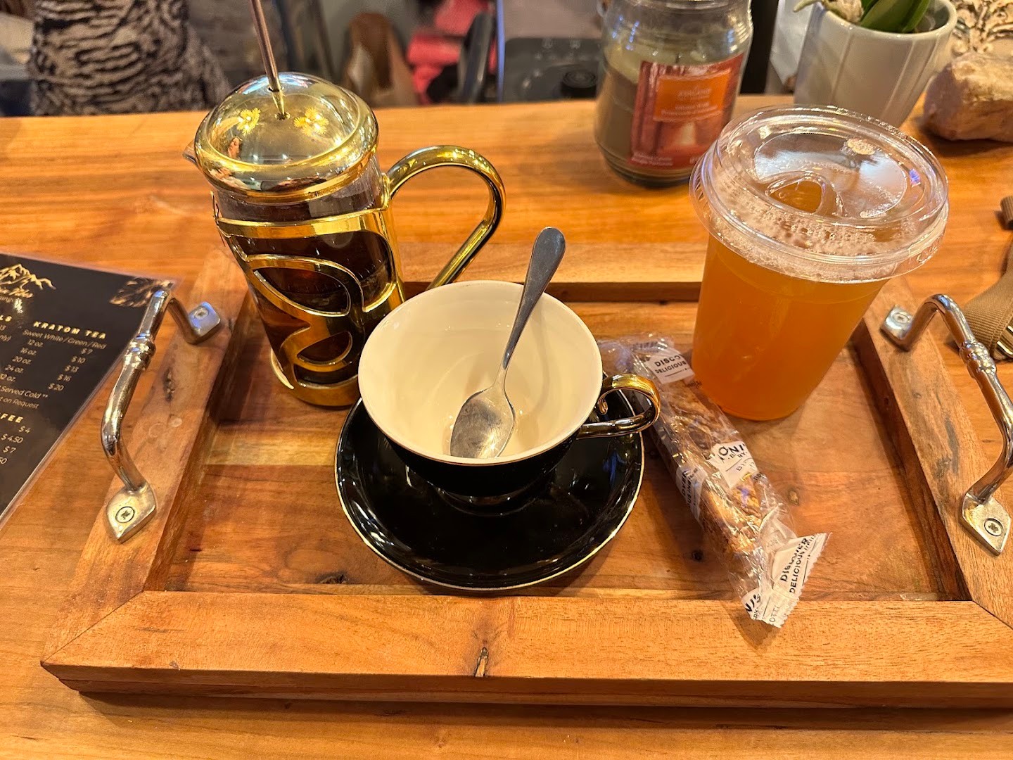 A French press, iced coffee and tea served on a wooden tray