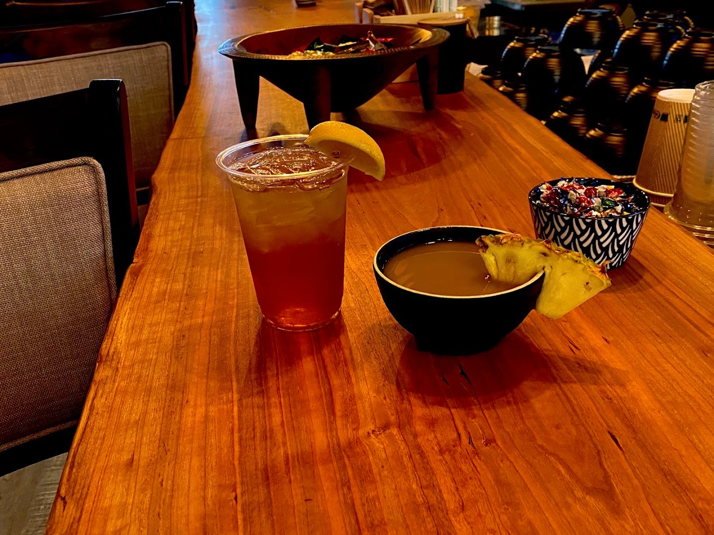 A traditional kava shell and an iced tea on the wooden bar