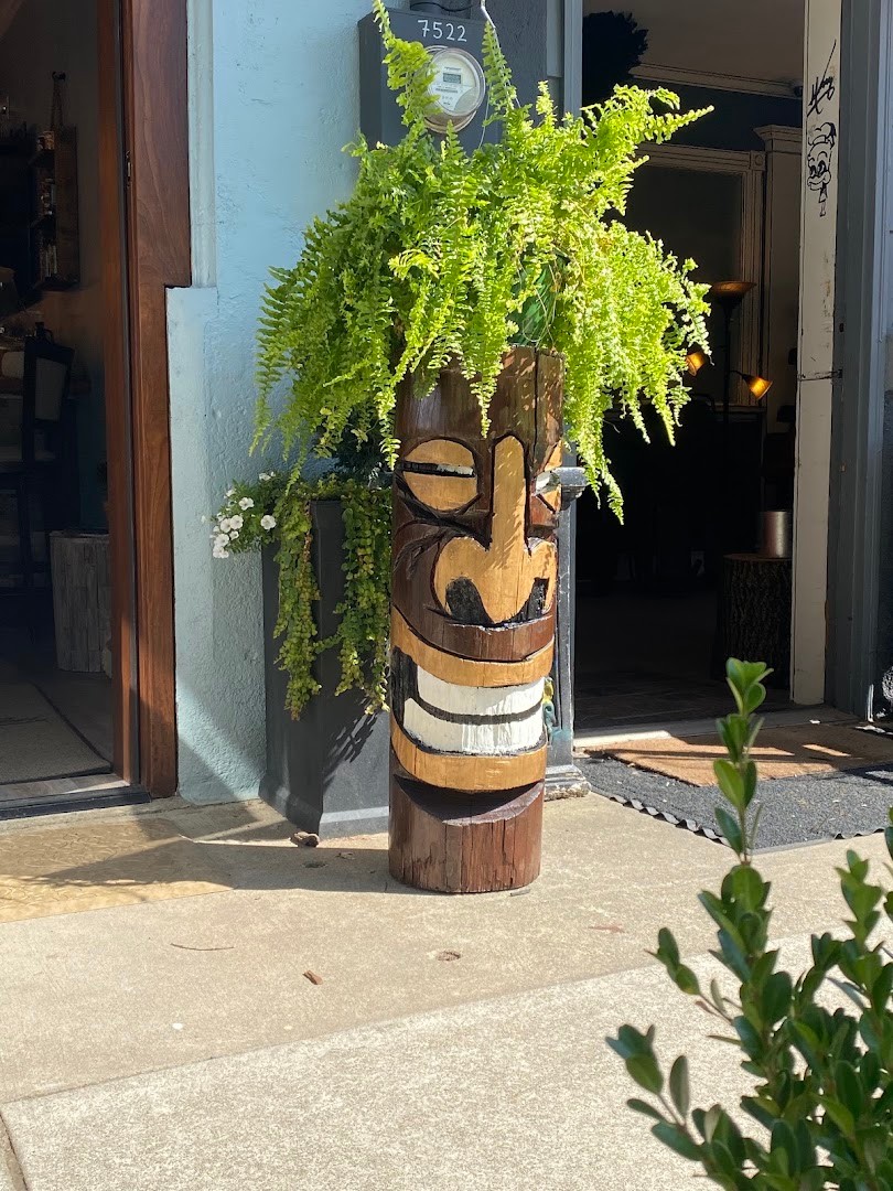 A tiki planter with ferns greeting guests at the door